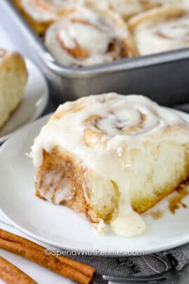 a cinnamon roll with frosting on a plate
