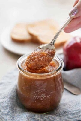 serving homemade apple butter with a spoon from a jar