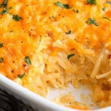 Hashbrown Casserole topped with cheese and parsley