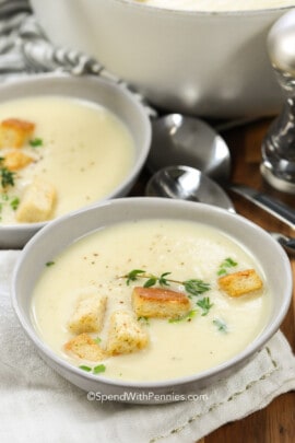 potato leek soup in a bowl garnished with croutons and herbs