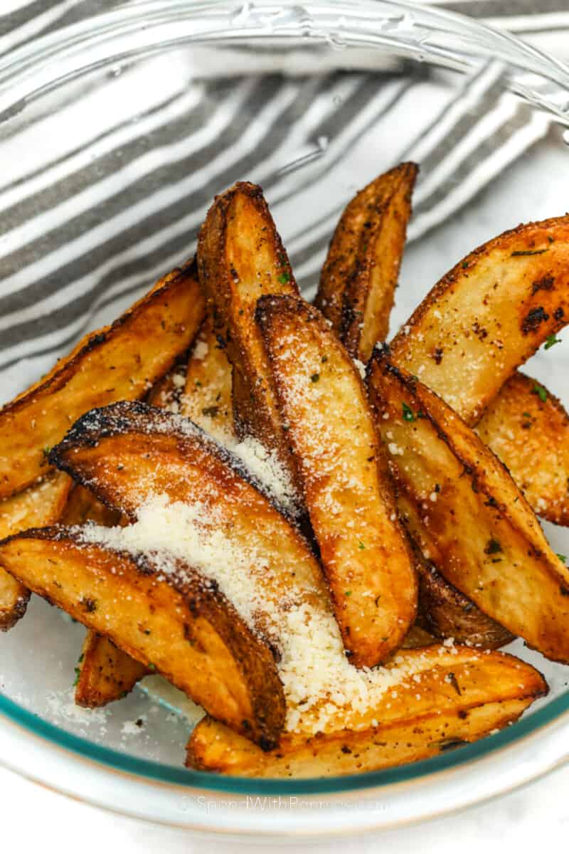 Air Fryer Potato Wedges topped with parmesan cheese in a bowl