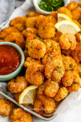 crispy popcorn shrimp on a tray with cocktail sauce
