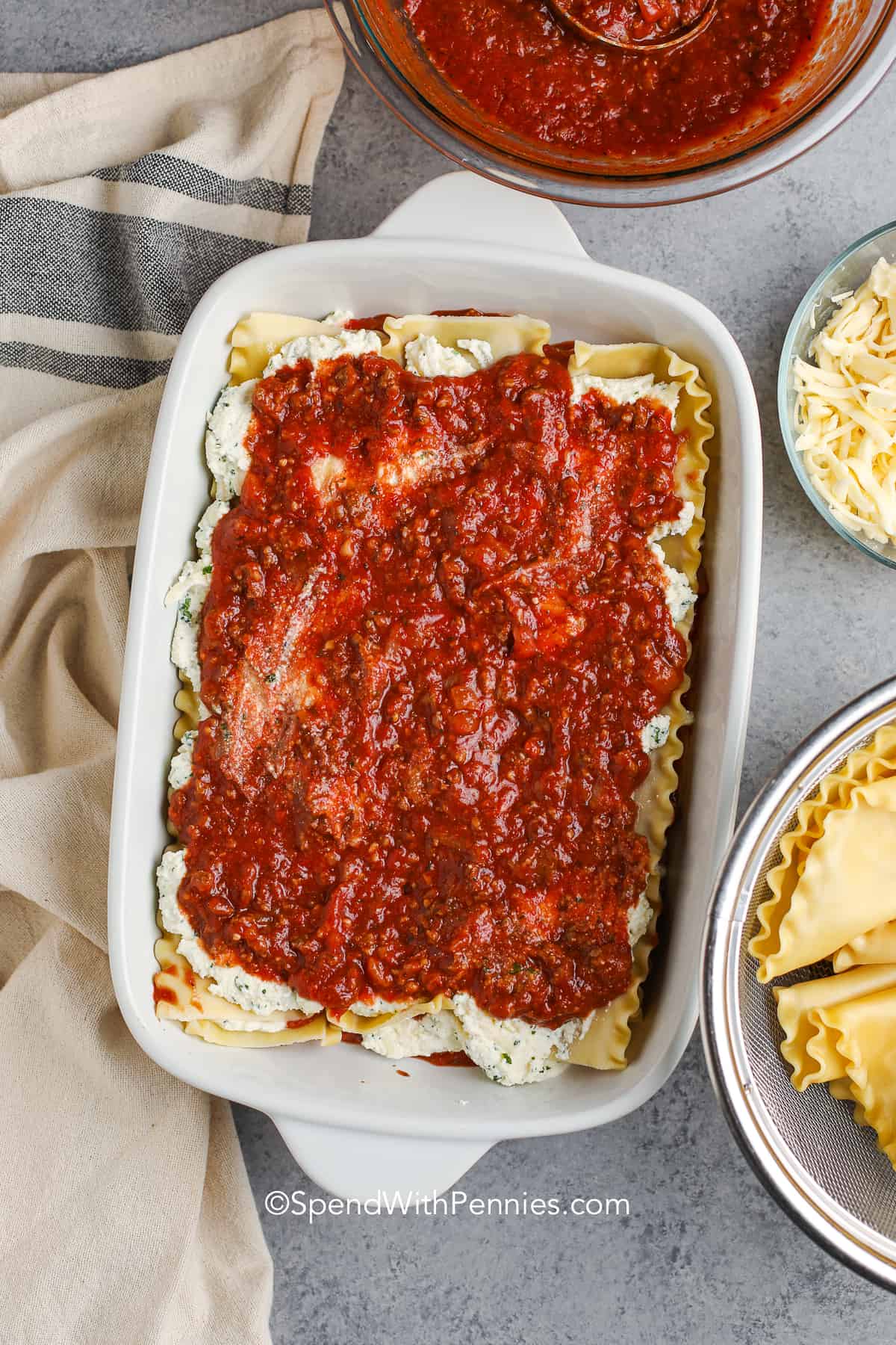 meat sauce spread over lasagna noodles with ricotta cheese