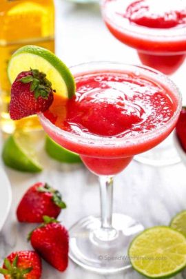 strawberry margarita garnished with lime and strawberry in a margarita glass