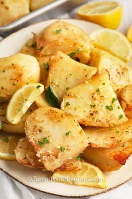 Greek Style Lemon Roasted Potatoes on a plate garnished with lemon and thyme
