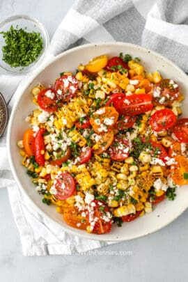 grilled corn and tomato salad topped with feta cheese and parsley
