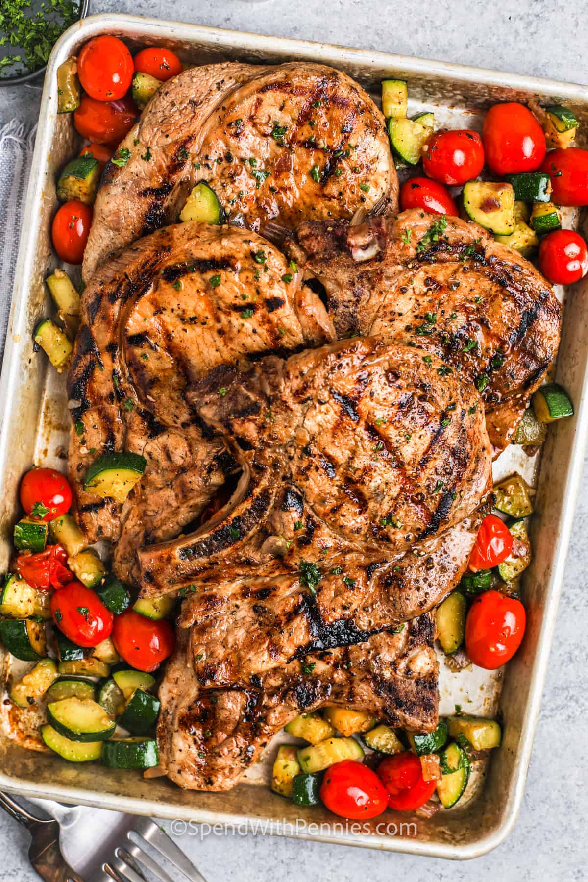 sheet pan full of Grilled Pork Chops and cooked vegetables