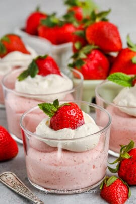Homemade Strawberry Mousse in cups with whipped cream and extra strawberries