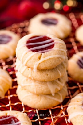 a stack of jam thumbprint cookies on a wire rack