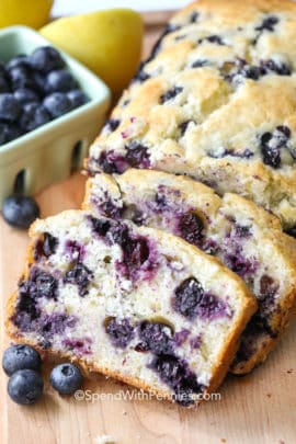 Sliced Lemon Blueberry Loaf with basket of blueberries next to it