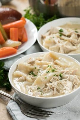 Two white bowls of Chicken and Dumplings