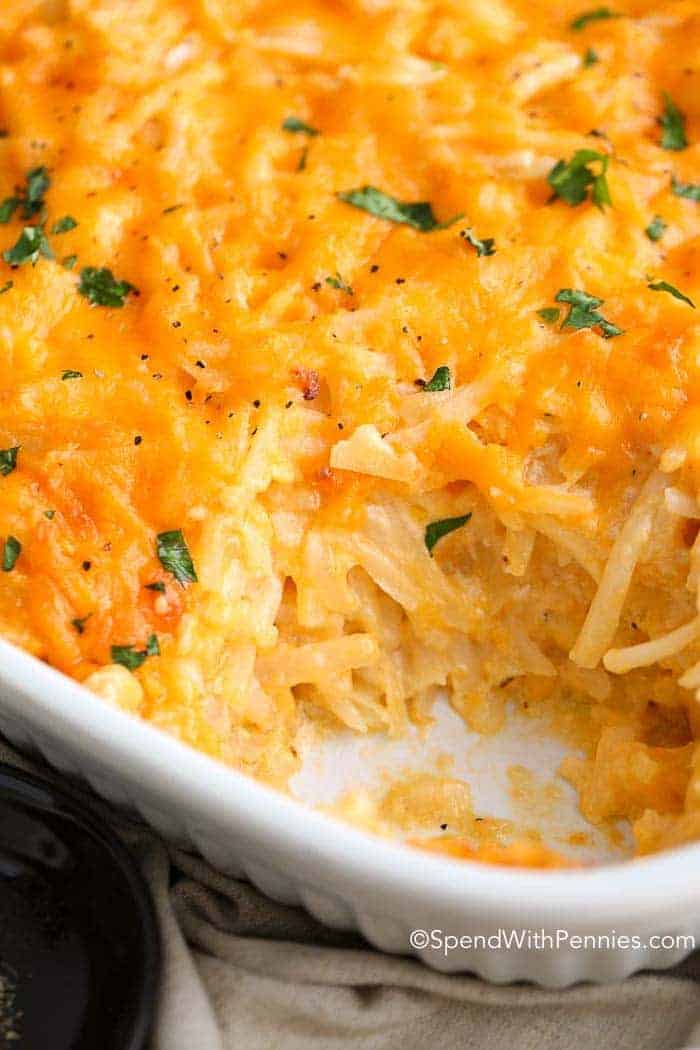 Close up of cheesy baked hashbrown casserole in a white casserole dish