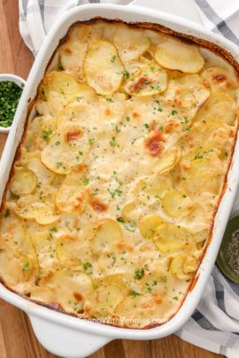 baked scalloped potatoes in dish with herbs
