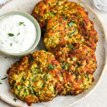 zucchini fritter patties on a plate with ranch