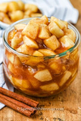 A jar of homemade apple pie filling with cinnamon sticks