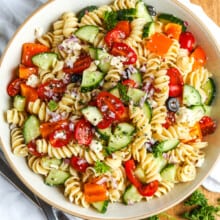 an an easy pasta salad in a white serving bowl with parsley