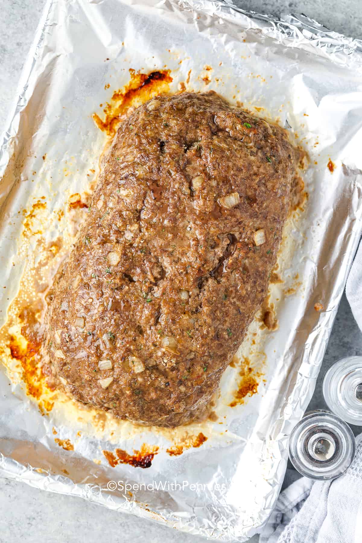 a baked meatloaf without sauce on a foil lined pan